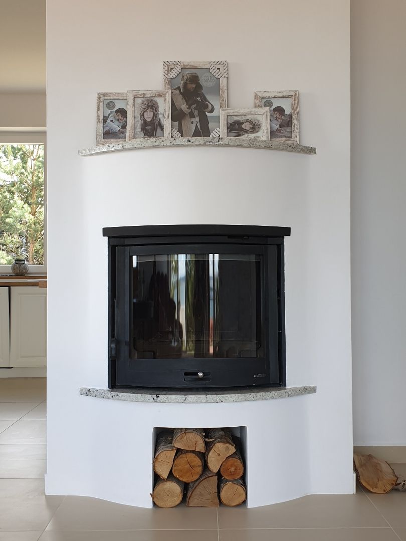 Kominek z szybą panoramiczną w nowoczesnej zabudowie.